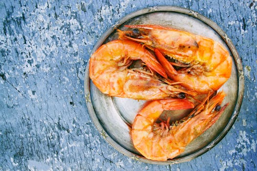 Top view of cooked shrimps on a metal plate on rustic surface. Perfect for seafood lovers.