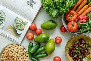 An appetizing display of fresh fruits and vegetables with a cookbook, perfect for healthy recipes.