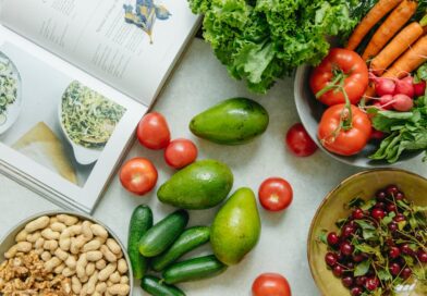 An appetizing display of fresh fruits and vegetables with a cookbook, perfect for healthy recipes.